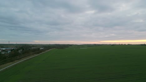 Aerial-View-Of-Green-Fields-Against-Cloudy-Sky-In-Poland---Drone-Shot