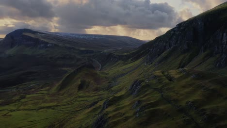 Proximity-reverse-aerial-overlooking-the-lush-Scottish-Highlands,-Isle-of-Skye,-Quiraing-Walk