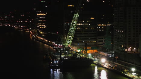 Aerial-view-orbiting-a-floating-construction-site,-night-in-Manhattan,-New-York