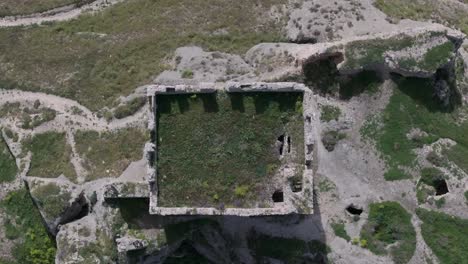 flight-with-a-drone-with-a-top-down-view-over-the-keep-of-the-castle-of-Oreja-9th-century-we-see-the-shadow-of-the-battlements-the-earthen-roof-on-the-ground-remains-of-its-wall-Ontigola-Toledo