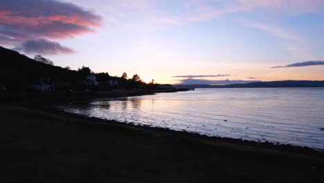 Beautiful-twilight-sunset-over-ocean-water-and-silhouetted-coastline-in-Lochranza-on-the-Isle-of-Arran,-west-coast-of-Scotland-UK