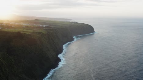 Drone-footage-of-lush-green-volcanic-island-countryside-and-ocean-bluffs-at-sunset-on-the-Azores-Sao-Miguel-Island