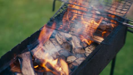 Wood-burning-and-catching-hot-flames-in-bbq-grill-food-preparation-close-up
