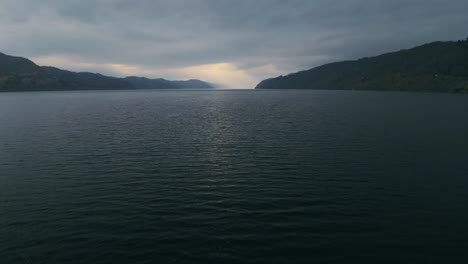 Dolly-Im-Tiefflug-über-Loch-Ness-Fängt-Ein-Strahlendes-Licht-Ein,-Das-Aus-Den-Wolken-Im-Schottischen-Hochland-Hervortritt