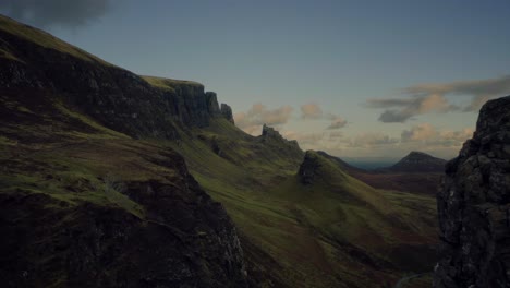 Dolly-in-aerial-skirting-the-cliffs-on-the-Quiraing-Walk,-Isle-of-Skye,-Scottish-Highlands