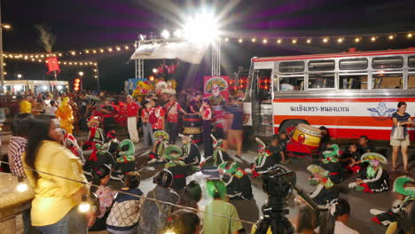 Timelapse-shot-of-a-lion-dance-performers-on-a-Chinese-New-Year-festival-celebration-on-the-ground-beside-their-red-bus-transport-while-waiting-for-their-turn-to-perform