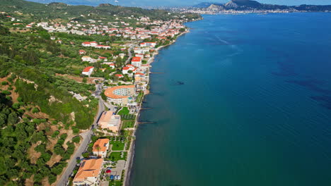 Iconic-tropical-coastline-township-with-mountains,-aerial-drone-view