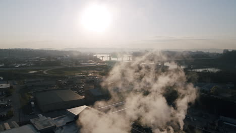Aerial-footage-panning-across-the-slowly-rising-steam-coming-off-a-factory-on-the-north-shore-of-Chattanooga,-TN