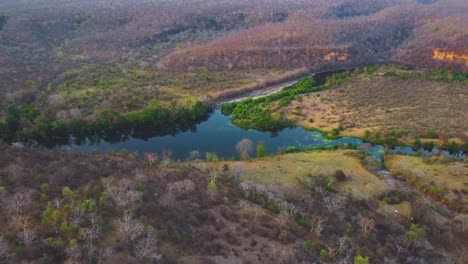 Toma-Aérea-Con-Drones-Del-Río-Parwati-Cubierto-De-Densos-Bosques-Semiáridos-Y-Colinas-A-Su-Alrededor-En-La-Zona-De-Shivpuri-De-Madhya-Pradesh,-India