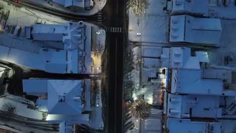 Schneebedeckte-Stadthäuser-Entlang-Der-Hauptstraße-Mit-Malerischen-Weihnachtsdekorationen-Und-Lichtern