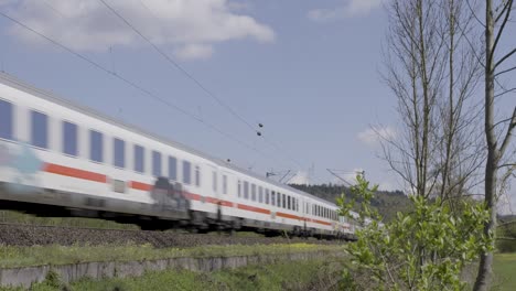 High-speed-train-rushing-through-a-lush-countryside-landscape-on-a-sunny-day