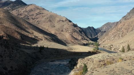 Drone-footage-of-an-empty-remote-landing-strip-surrounded-by-mouintains-near-a-river-in-the-Frank-Church-River-of-No-Return-Wilderness-in-Idaho