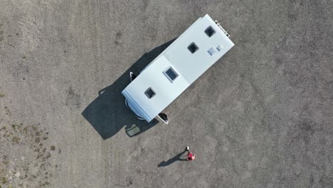 Toma-De-Arriba-Hacia-Abajo-De-Un-Hombre-Caminando-Hacia-Su-Camioneta,-Estacionada-En-Un-Camino-De-Tierra