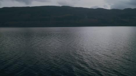 Fast-low-flight-over-Loch-Ness-looking-over-the-Scottish-Highlands,-dolly-in