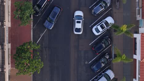 La-Jolla-Cove-Street-Drone-Top-Down-View-With-Parked-Cars,-White-Car-Drives-Through-Frame-Bottom-to-Top