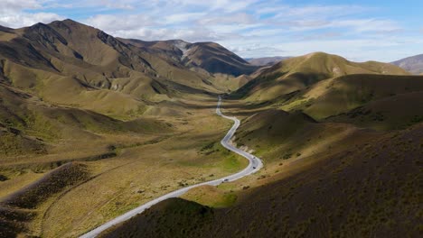 Un-Camino-Sinuoso-A-Través-Del-Paso-De-Lindis-En-Nueva-Zelanda,-Que-Muestra-Un-Terreno-Accidentado-Y-Una-Belleza-Remota,-Vista-Aérea