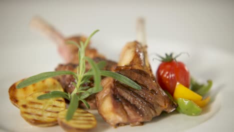 Grilled-lamb-chops-plated-elegantly-with-grilled-vegetables-and-fresh-herbs,-close-up