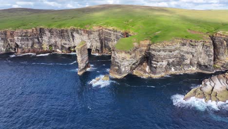 Aerial-View-of-Sea-Stack-and-Steep-Cliffs-on-Coastline-of-Scotland-UK,-Cinematic-Drone-Shot