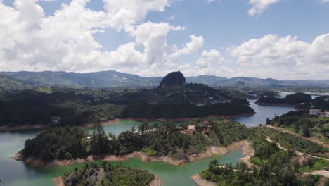 Drone-ascends-above-winding-river-in-El-Penon-de-Guatape-Colombia-at-midday