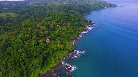 Overhead-view-looking-down-on-rich-blue-Pacific-Ocean-water-along-a-lush-green-forest-of-trees-on-the-Osa-Peninsula-in-Costa-Rice-near-Drake-Bay