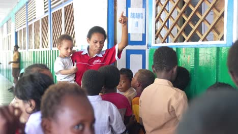 Papua-Indonesien-Klassenzimmer-Mit-Kindern-Und-Lehrer-Mit-Baby-In-Der-Hand