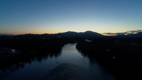 Aerial-footage-flying-over-the-Sacramento-River-after-sunset-in-Redding,-California