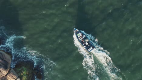 Aerial-top-view-of-fishing-boat-sailing-coastline-of-Barra-Da-Lagoa-canal,-Santa-Catarina,-Florianópolis,-Brazil