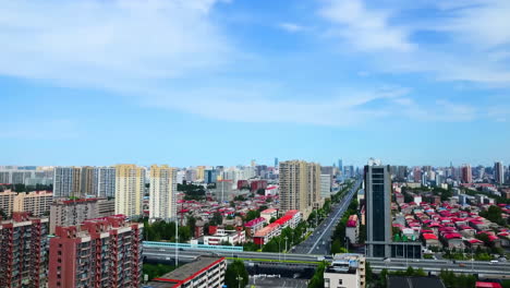 Vista-Del-Tráfico-De-Automóviles-En-La-Intersección-De-Carreteras-Y-Autopistas-En-Una-Ciudad-Moderna-Con-Rascacielos-Emblemáticos-Bajo-El-Cielo-Azul,-Video-De-Lapso-De-Tiempo-Del-Puente