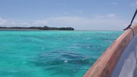 POV-sailing-on-turquoise-sea-water-from-inside-fishing-boat,-Los-Roques-Venezuela