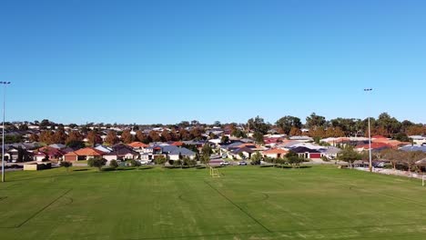 Aerial-rise-up-clip-over-empty-football-pitches-on-sunny-day,-Riverlinks-Park,-Clarkson