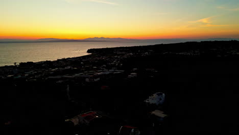 Vibrante-Puesta-De-Sol-Y-Silueta-De-La-Ciudad-Costera,-Vista-Aérea-De-Drones