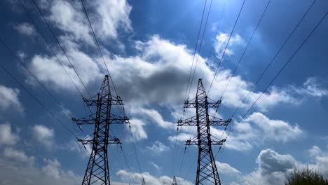 Dos-Torres-De-Transmisión-Simétricamente-Una-Al-Lado-De-La-Otra-Durante-Un-Día-Soleado-Con-Nubes