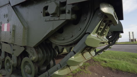 Churchill-tank-memorial-ww2-Carrickfergus-green,-tracks-large-metal,-panning-right-to-left