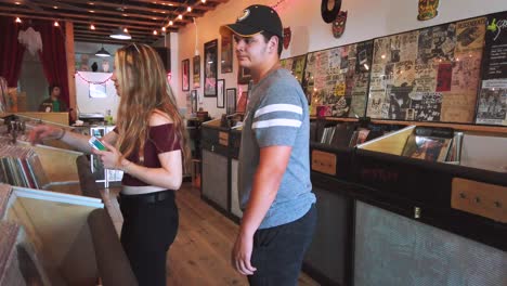 Static-footage,-couple-in-vintage-record-store,-Voodoo-Vinyl,-in-the-day,-looking-at-LP's-or-records,-smiling-having-fun,-in-Los-Angeles,-California