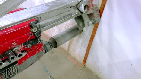 A-red-colored-core-cutting---drilling-machine-used-to-drill-a-core---hole-in-a-concrete-wall