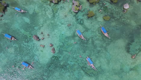 Top-down-view-over-boats-in-turquoise-water-in-Kwale-Island-coral-reef-lagoon