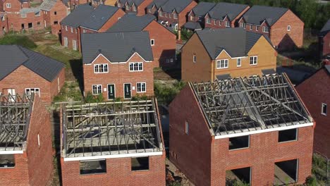 Residential-housing-estate-aerial-view-circling-unfinished-property-framework-on-building-development-site-during-recession