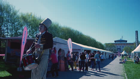 Clown-on-walking-sticks-with-a-drum