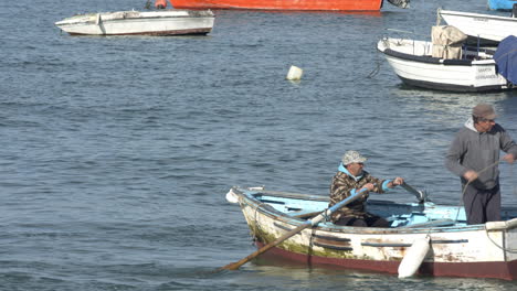 Boat-owners-moving-its-boat-to-not-aground-at-the-river-bank-at-Tejo'River-in-Lisbon