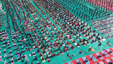 Luftaufnahmen-Von-Menschen,-Die-In-Einem-Stadion-In-Ahmednagar,-Indien,-Anlässlich-Des-Internationalen-Yoga-Tages-Zusammen-Mit-Schülern-Yoga-Machen