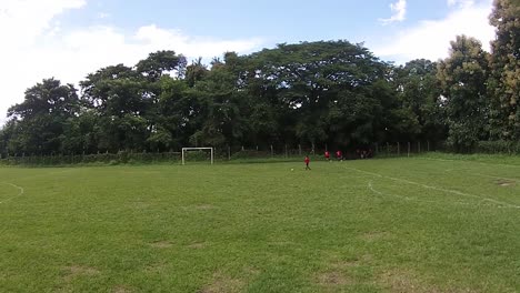 Vista-De-Un-Grupo-De-Mujeres-Jóvenes-En-Medio-De-Un-Entrenamiento-De-Fútbol,-Grabado-Desde-Un-Dron