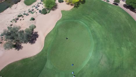 Golfista-Aéreo-Camina-Hasta-El-Hoyo-Mientras-Otro-Golfista-Se-Prepara-Para-Patear,-Campo-De-Golf-Westin-Kierland,-Scottsdale,-Concepto-De-Arizona:-Ejercicio,-Caridad,-Turismo