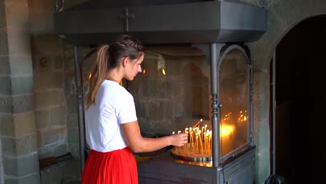 Frau-Zündet-In-Einem-Kloster-Eine-Kerze-An