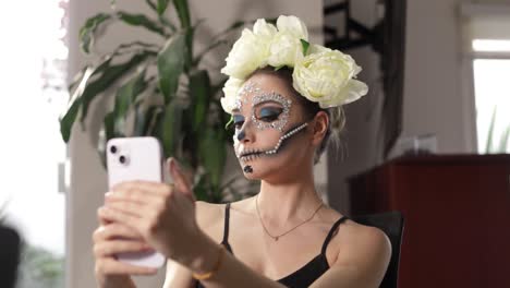 Mexican-model-in-Catrina-or-skull-woman-costume-checking-up-the-final-result-of-her-makeup