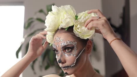 Modelo-Mexicana-Obteniendo-Los-últimos-Detalles-De-Su-Maquillaje-Y-Disfraz-De-Catrina,-Revisando-El-Orden-De-Su-Corona-Floral