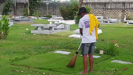 Cemetery-caretaker-cleans-graveyard-tombs-inside-manila-memorial-park-in-manila,-Philippines