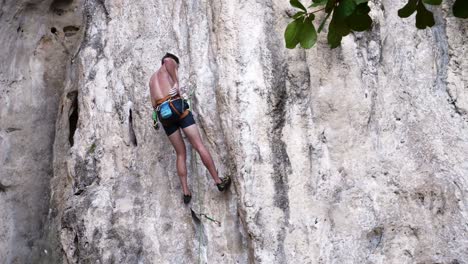 Young-travelers-with-a-rope-engaged-in-the-sports-of-rock-climbing-on-the-rock-at-Krabi-in-Thailand