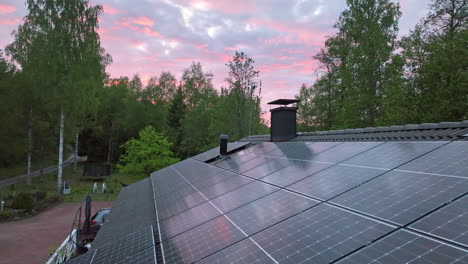 Dramatischer-Wolkiger-Sonnenuntergangshimmel-über-Einem-Hausdach-Mit-Solarzellen---Luftaufnahme