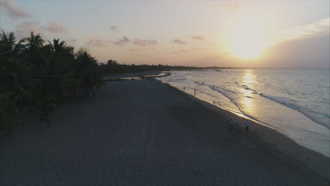 AERIAL:-Slow-motion-sunset-on-Honduran-beach---Tela,-Honduras-2