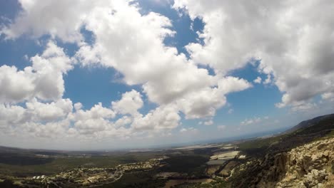 A-timelapse-of-Clouds-passing-by-near-a-cliff-above-a-village-the-clouds-pass-by-slowly-and-carefully-and-you-can-at-times-see-a-guy-having-fun-near-the-cliff
